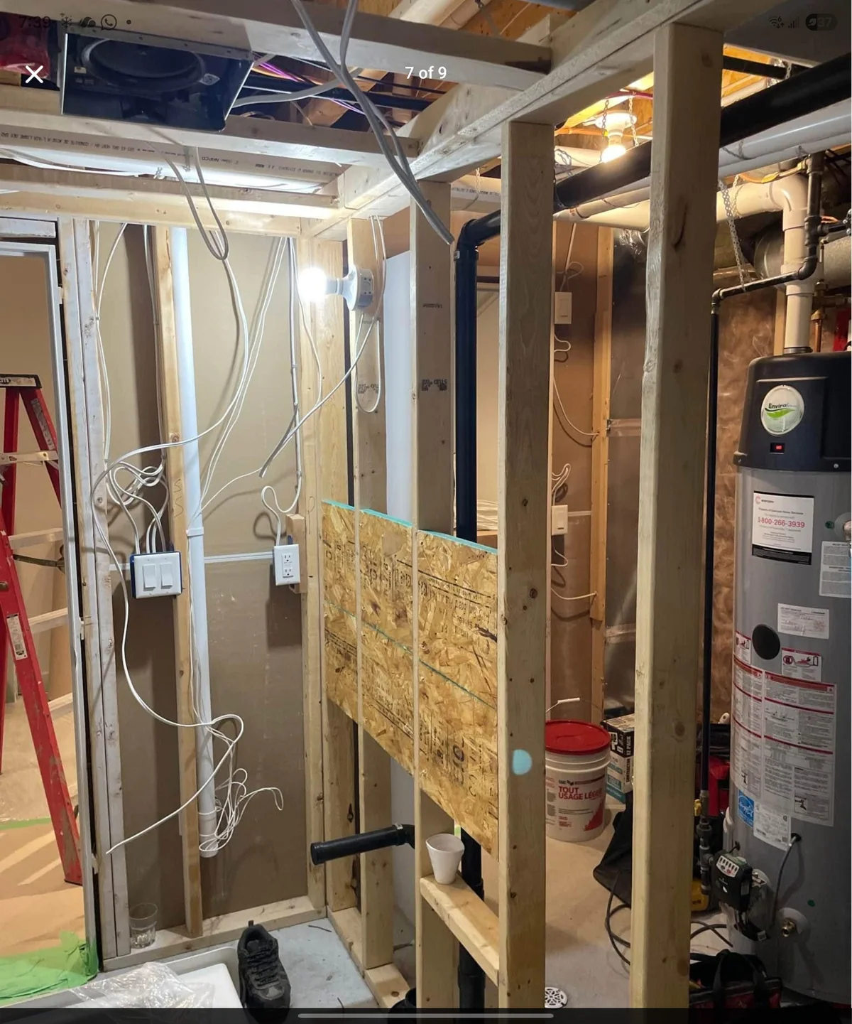 Basement framing in progress around mechanical equipment and electrical wiring