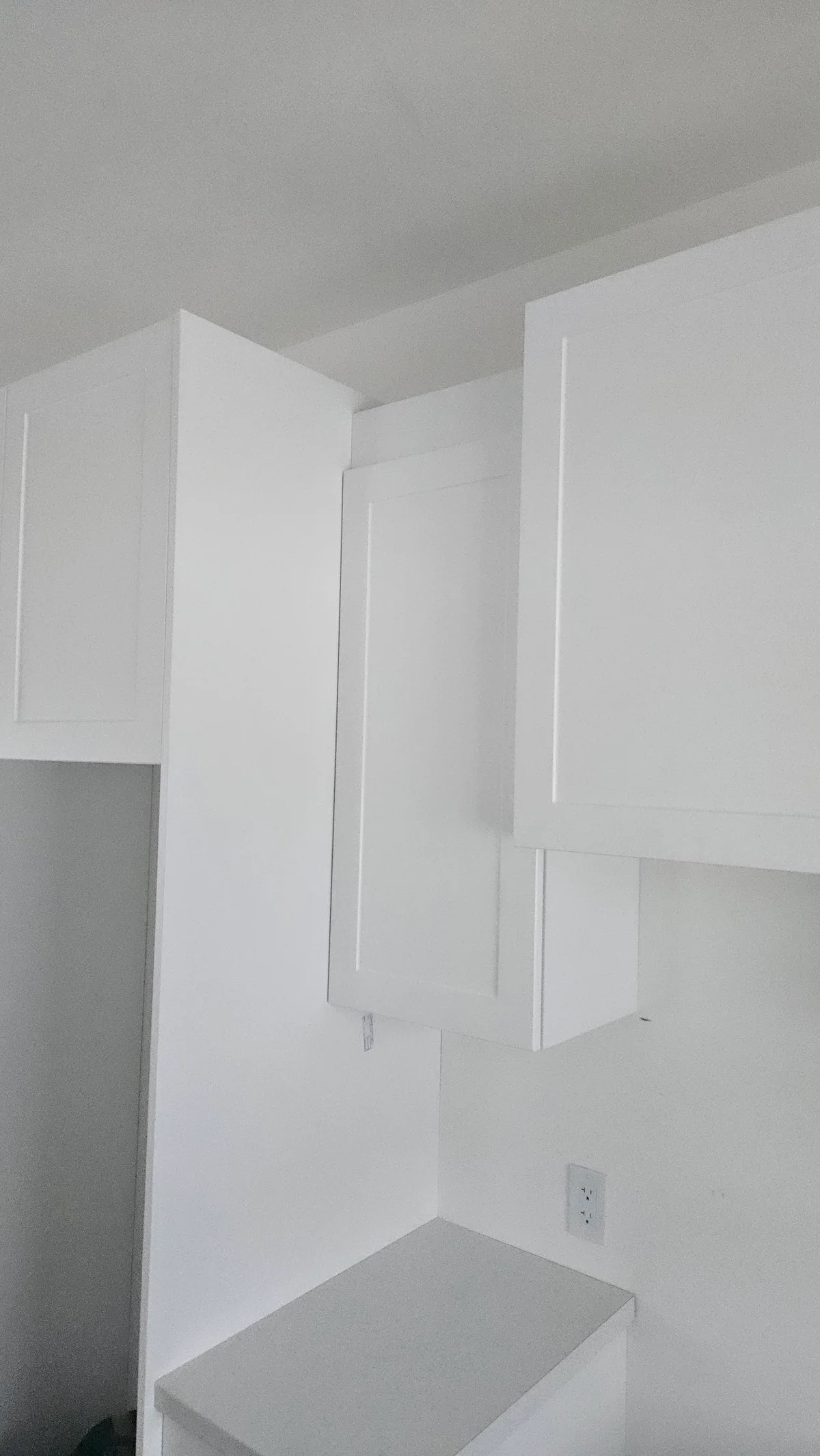 White wall cabinets installed above a compact built-in work nook