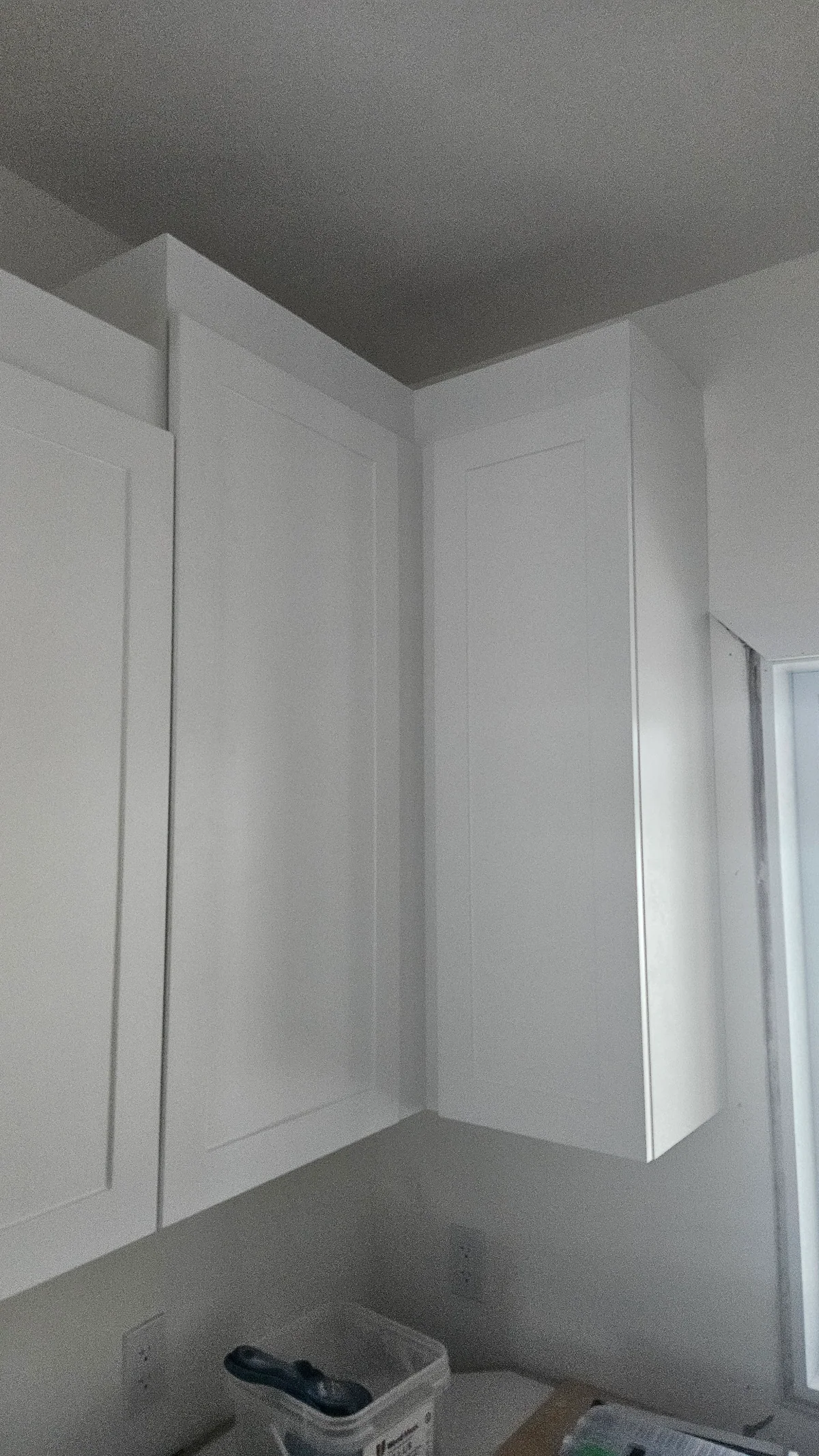 Tall white cabinetry surrounding a recessed counter and storage area