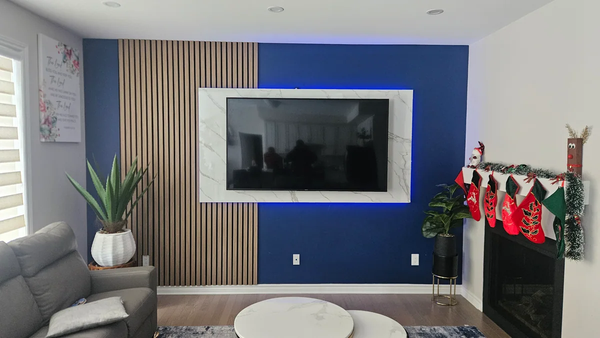Living room media wall with blue accent panel, television, and wood slats
