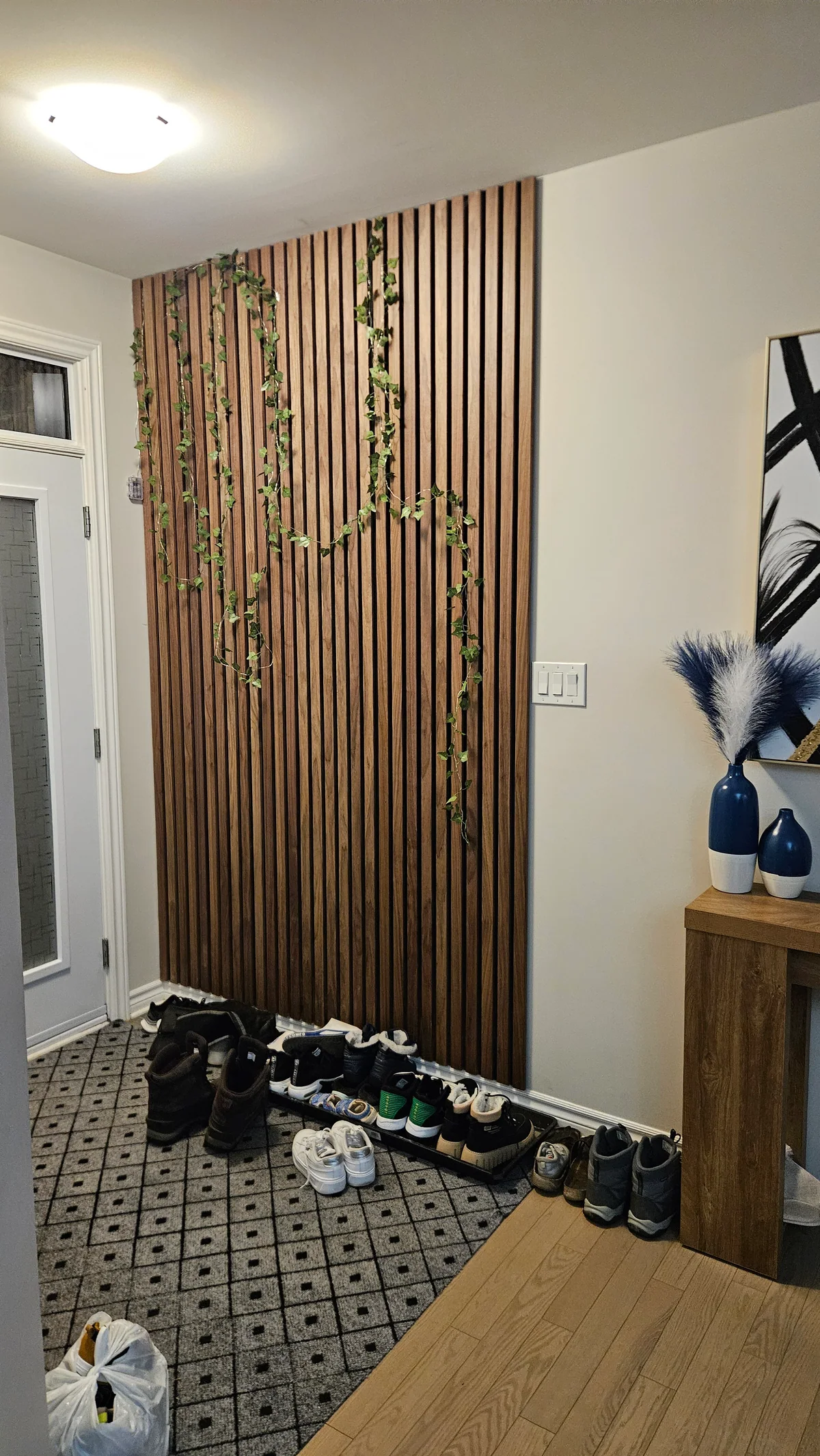 Entry feature wall with vertical wood slats and integrated coat hooks