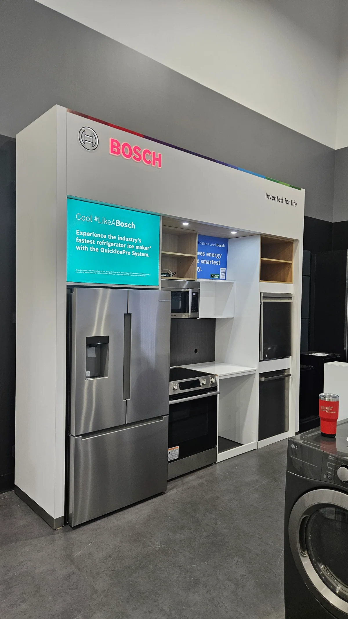 Bosch refrigerator and oven display framed by white custom cabinetry