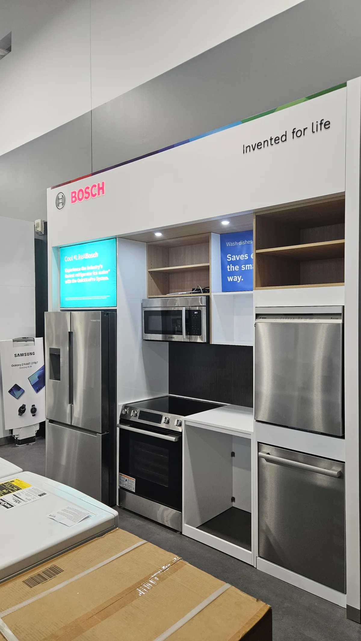 Tall Bosch refrigerator and oven display wall with fitted white cabinetry
